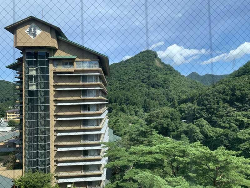 ホテル華の湯の高層の建物と後ろの山