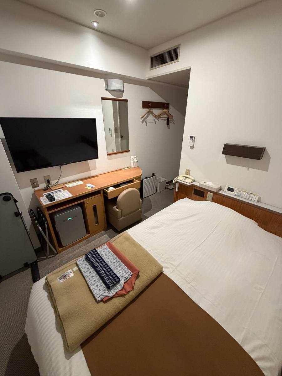 スターホテル郡山のシングルルーム。ベッドとテレビ、デスク